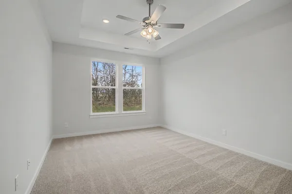a view of an empty room and chandelier fan