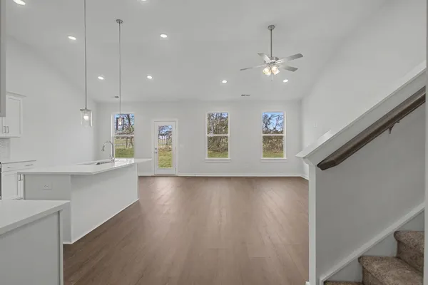 a view of kitchen with center island stainless steel appliances wooden floor and window