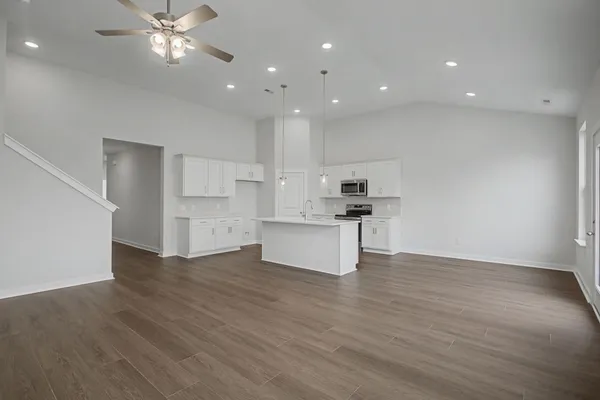 an open kitchen with a sink and a stove top oven