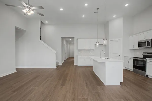 a large kitchen with stainless steel appliances granite countertop a large counter top a sink and a stove