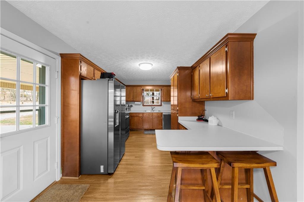6124 Clyde Conner Road Murrayville, GA 30564 - Photo 11 of 48 a kitchen with stainless steel appliances granite countertop a refrigerator a sink dishwasher and a stove with wooden floor
