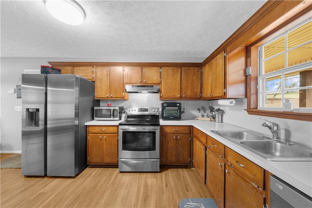 6124 Clyde Conner Road Murrayville, GA 30564 - Photo 13 of 48 a kitchen with stainless steel appliances granite countertop a sink stove and refrigerator