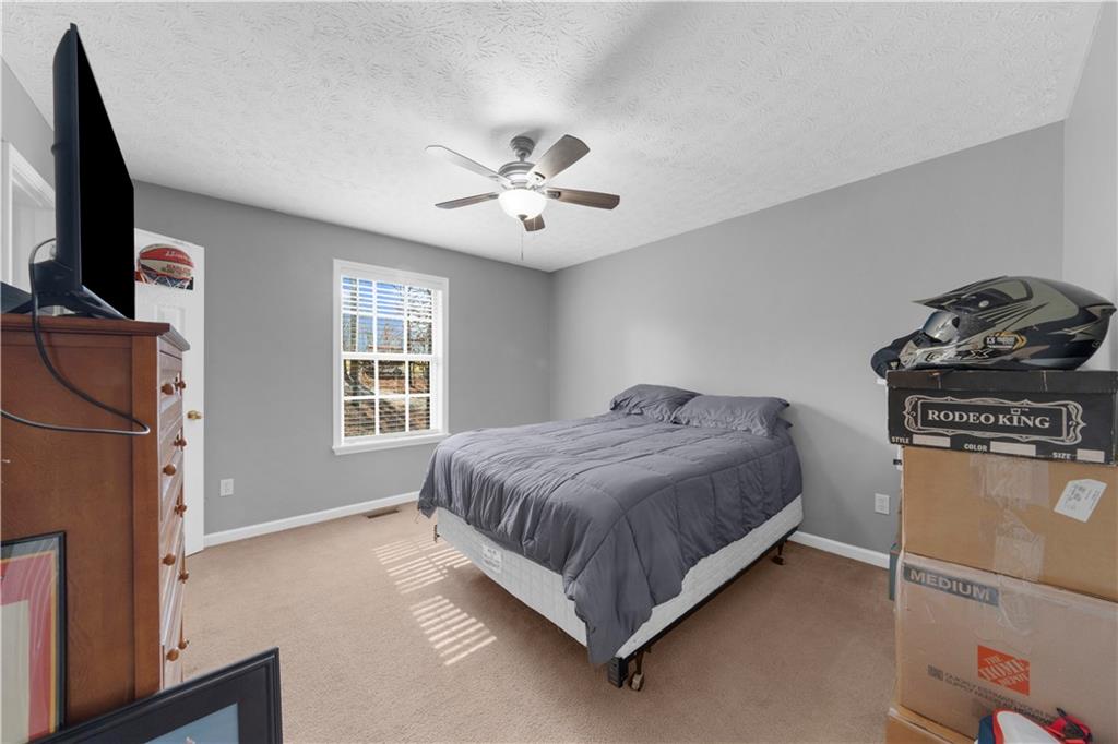 6124 Clyde Conner Road Murrayville, GA 30564 - Photo 21 of 48 a bedroom with a bed flat screen tv and windows