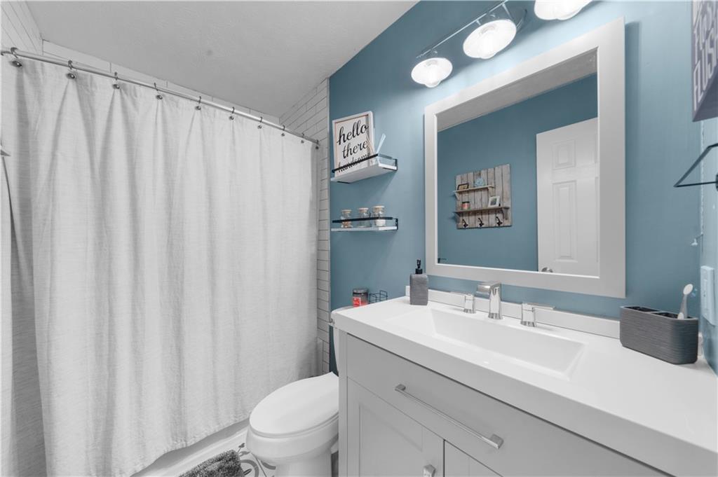 6124 Clyde Conner Road Murrayville, GA 30564 - Photo 22 of 48 a bathroom with a sink a toilet and shower curtain