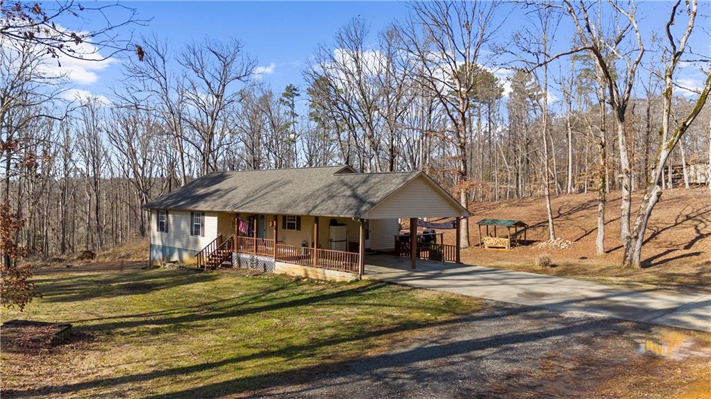 6124 Clyde Conner Road Murrayville, GA 30564 - Photo 40 of 48 a backyard of a house with table and chairs under an umbrella