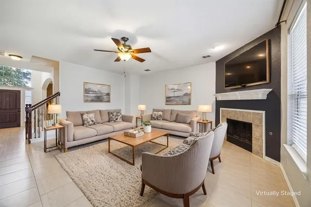 a living room with furniture a fireplace and a flat screen tv