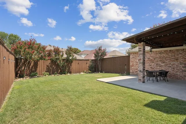 a backyard of a house with table and chairs