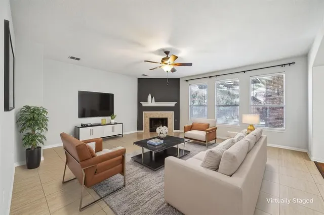 a living room with furniture a flat screen tv and a fireplace