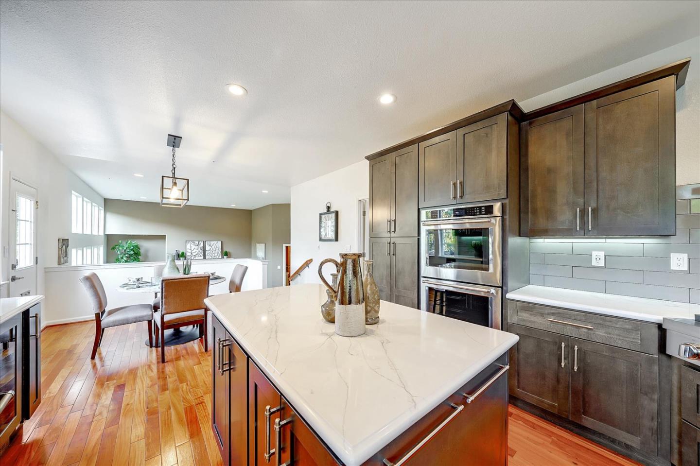 93 Ralston Ranch Road Belmont, CA 94002 - Photo 14 of 49 a kitchen with stainless steel appliances a kitchen island hardwood floor sink stove dining table and chairs