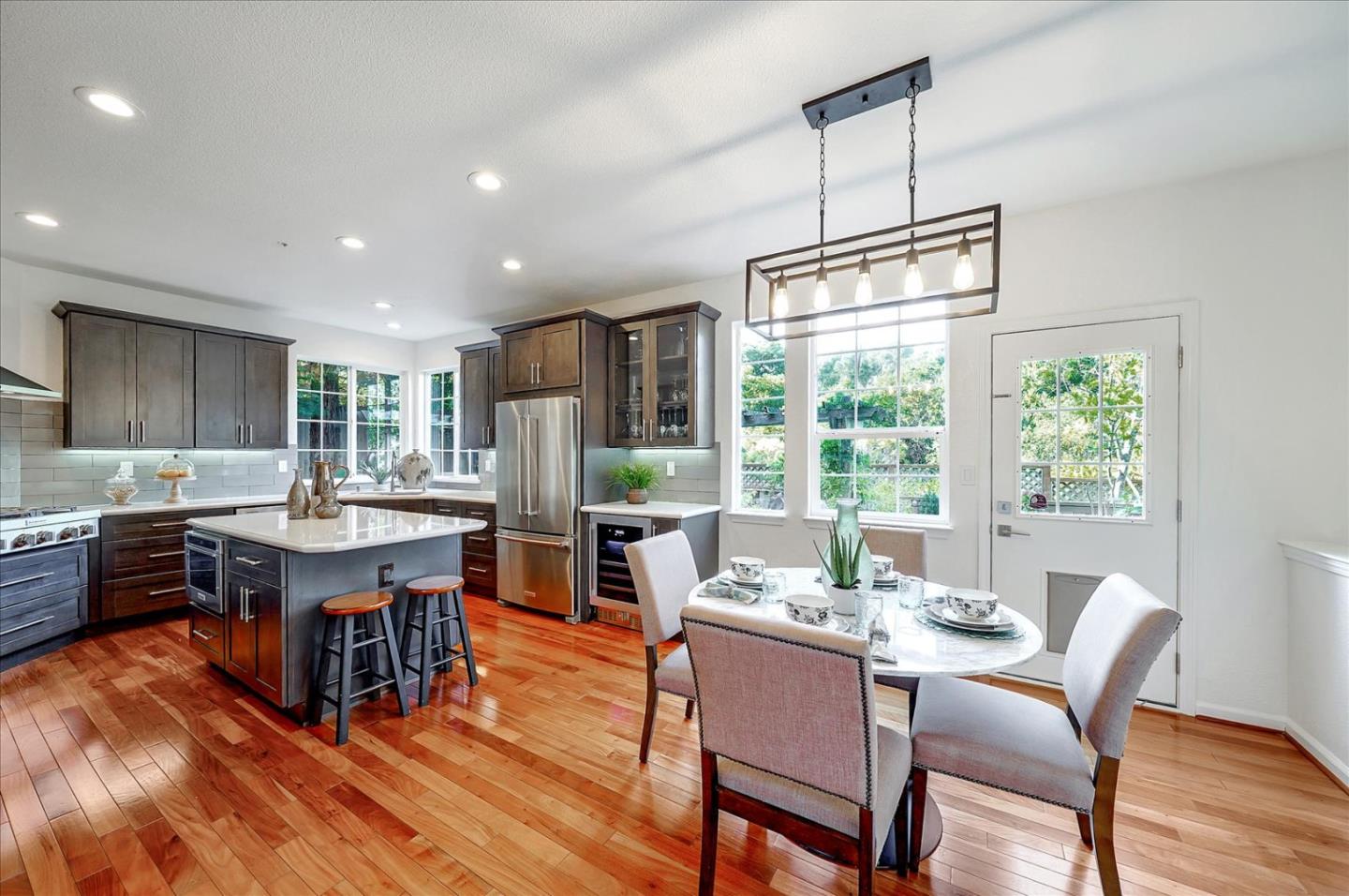 93 Ralston Ranch Road Belmont, CA 94002 - Photo 15 of 49 a dining room with wooden floor a chandelier a wooden table and chairs