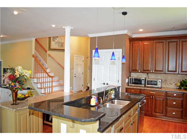 149 Chimney Rise Drive Cary, NC 27511 - Photo 11 of 24 a kitchen with stainless steel appliances kitchen island granite countertop a sink refrigerator and cabinets