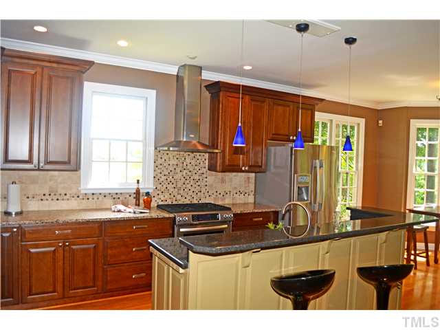 149 Chimney Rise Drive Cary, NC 27511 - Photo 7 of 24 a kitchen with stainless steel appliances granite countertop a sink stove and cabinets