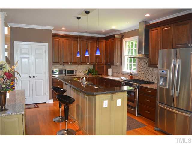 149 Chimney Rise Drive Cary, NC 27511 - Photo 8 of 24 a kitchen with stainless steel appliances granite countertop a sink stove and refrigerator