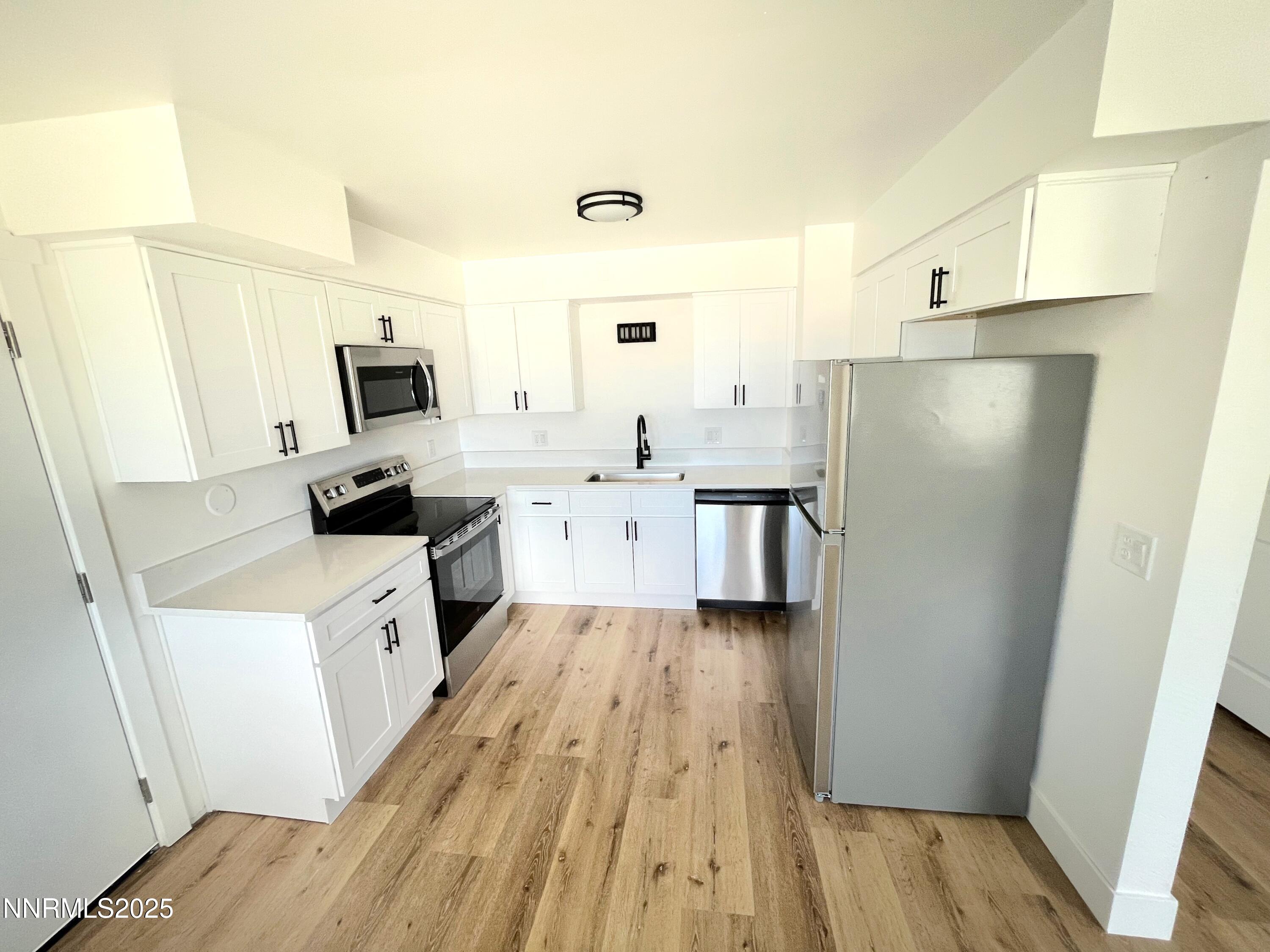 905 East Taylor Street Reno, NV 89502 - Photo 6 of 23 a kitchen with white cabinets and stainless steel appliances