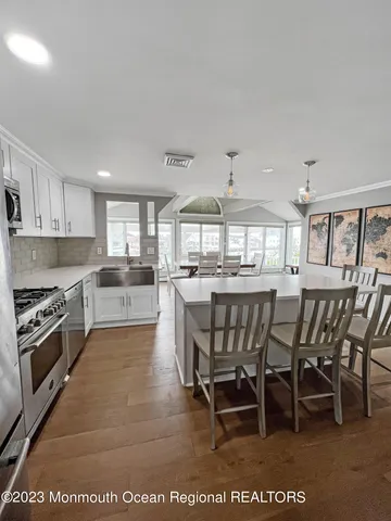 a kitchen with white cabinets and sink