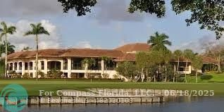 7876 La Mirada Drive Boca Raton, FL 33433 - Photo 24 of 34 a view of a white house with a big yard and potted plants