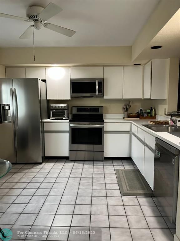 7876 La Mirada Drive Boca Raton, FL 33433 - Photo 8 of 34 a kitchen with a sink stainless steel appliances and cabinets