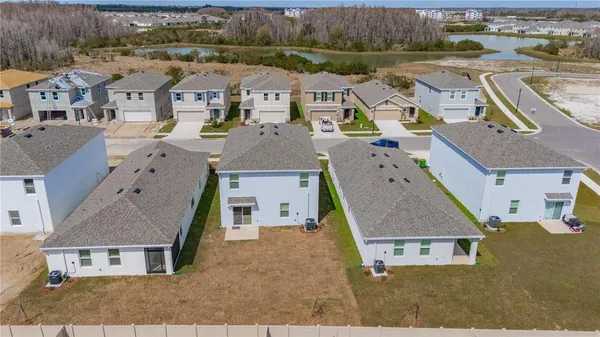 an aerial view of residential houses with outdoor space and parking