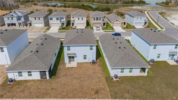 an aerial view of residential houses with outdoor space and parking