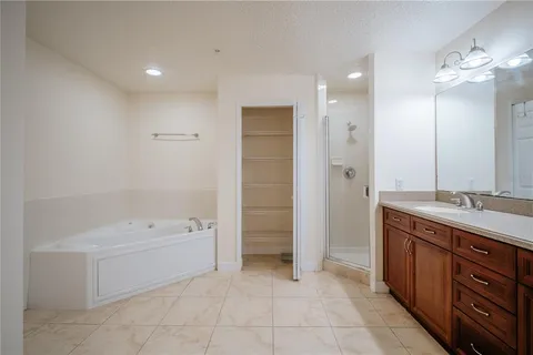 a bathroom with a granite countertop double vanity sink a mirror and shower