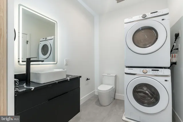 a living room with mirror a washer and dryer