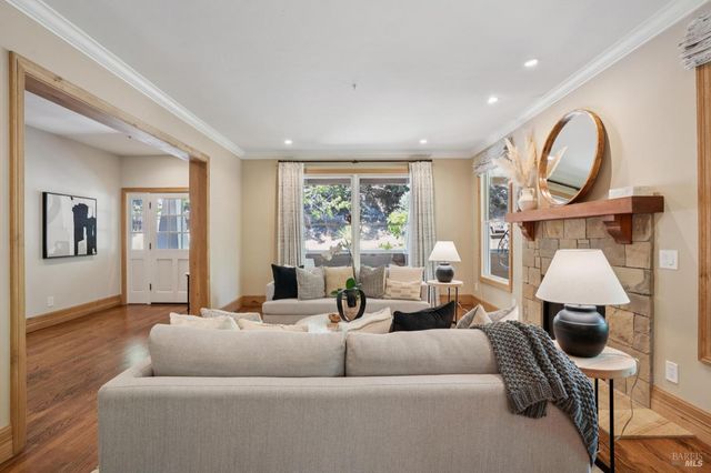 a living room with furniture a fireplace and a floor to ceiling window