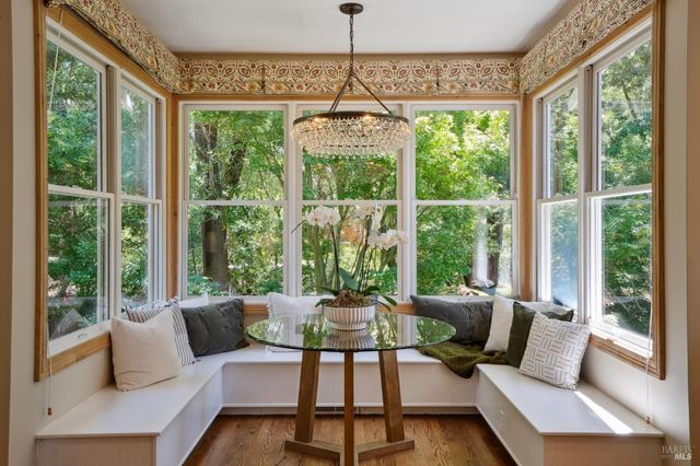 a view of a hallway with wooden floor and windows
