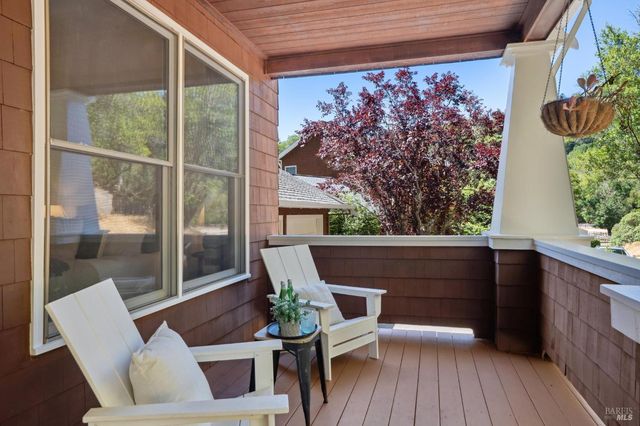a view of a hallway with wooden floor and a living room