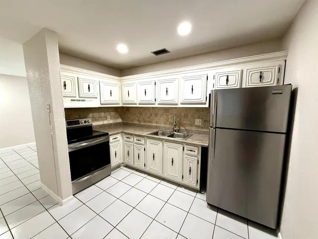 a kitchen with stainless steel appliances granite countertop a refrigerator and a stove top oven