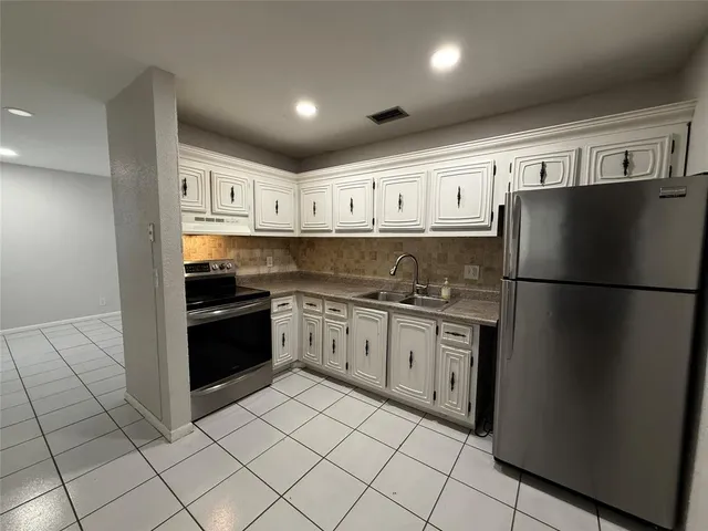 a kitchen with stainless steel appliances granite countertop a refrigerator and a sink