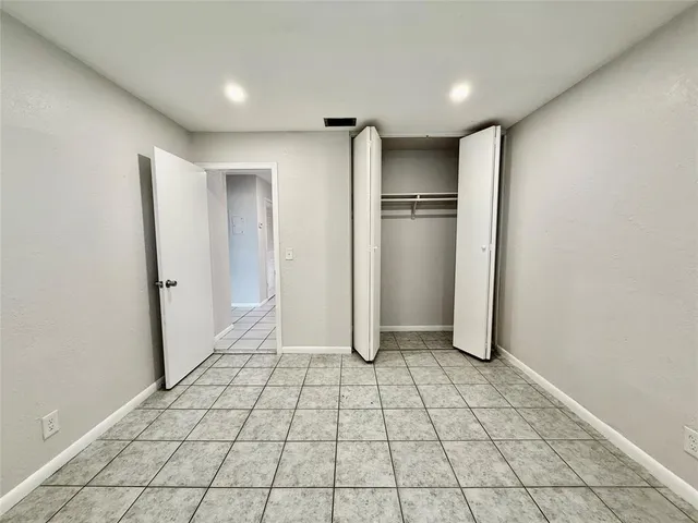 a view of a refrigerator in kitchen and an empty room