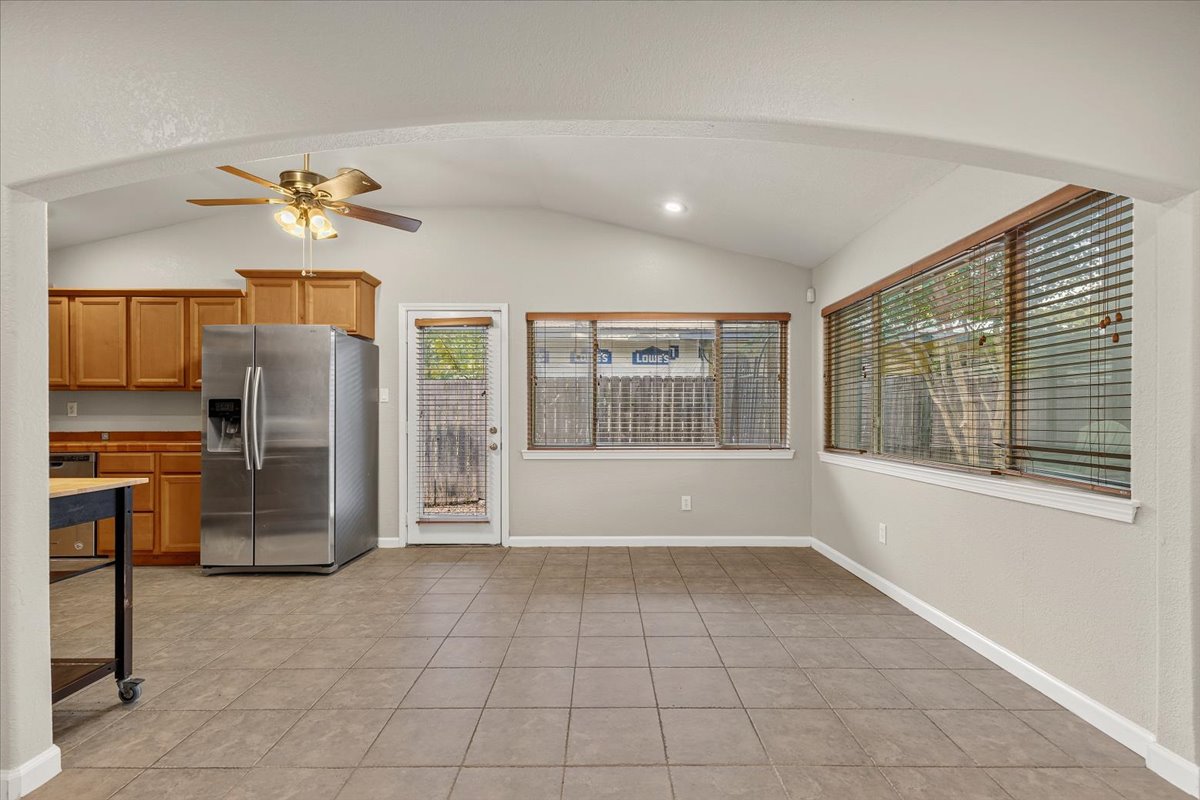 7604 Robalo Road Austin, TX 78757 - Photo 5 of 36 A well-lit kitchen and dining area features tile flooring and outdoor views.
