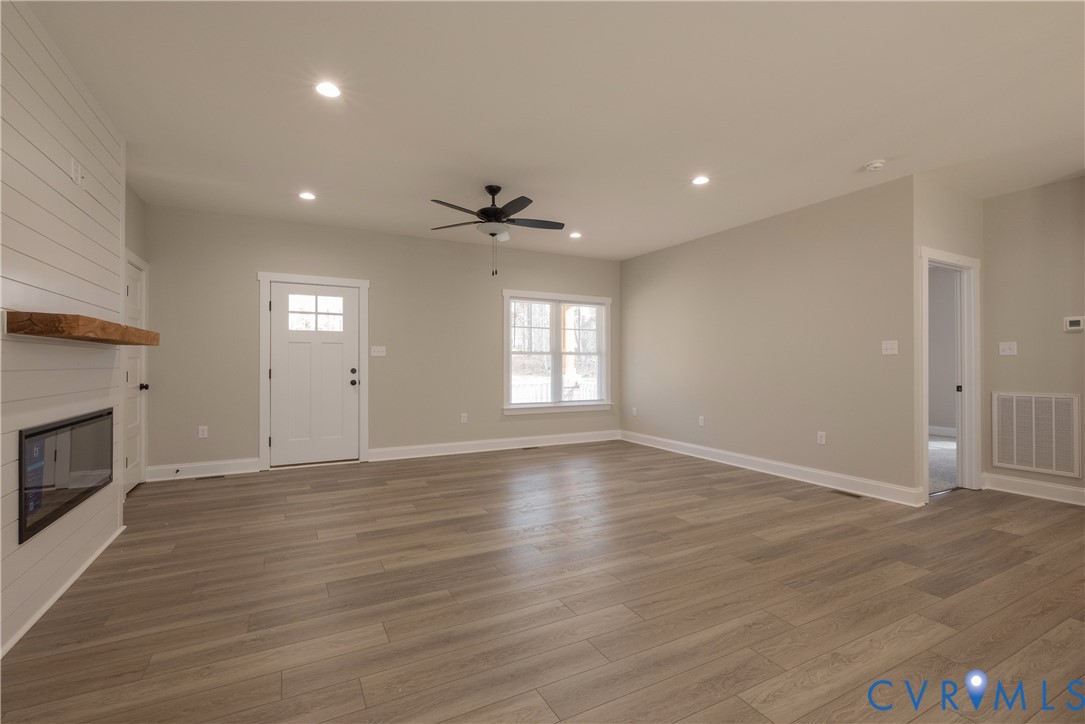 2223 Ridge Road Arvonia, VA 23004 - Photo 12 of 45 a view of an empty room with wooden floor fireplace and a window