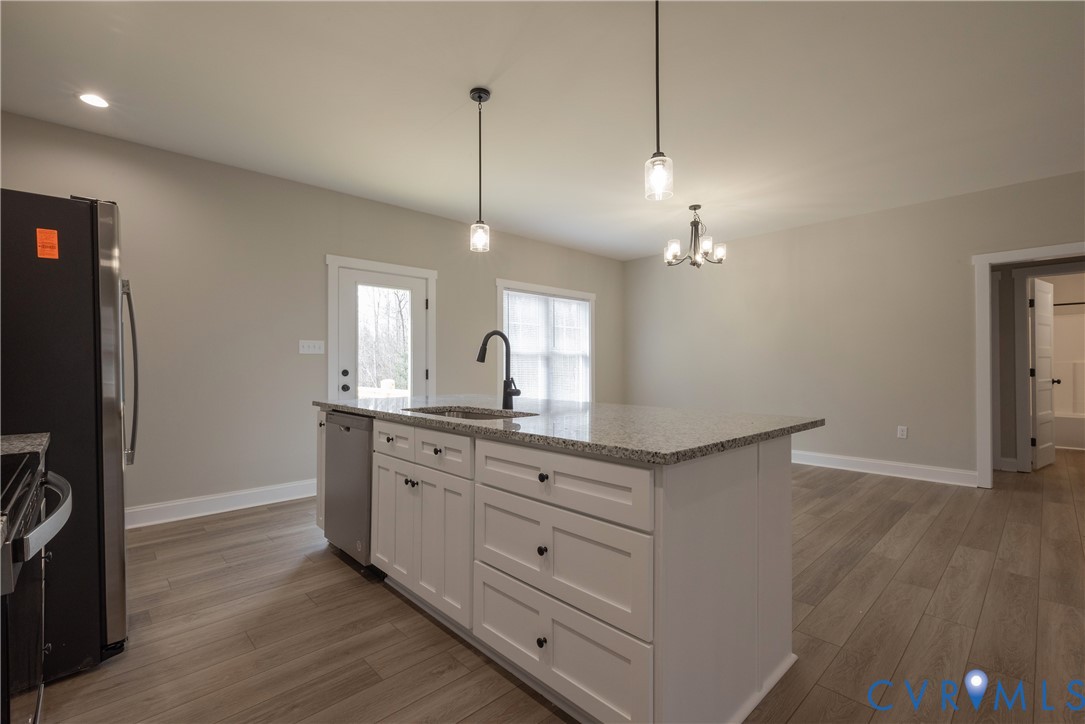 2223 Ridge Road Arvonia, VA 23004 - Photo 20 of 45 a kitchen with granite countertop a refrigerator a sink and wooden floor