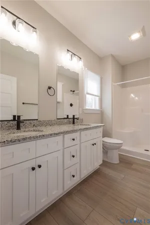 a bathroom with a granite countertop sink a toilet and a large mirror