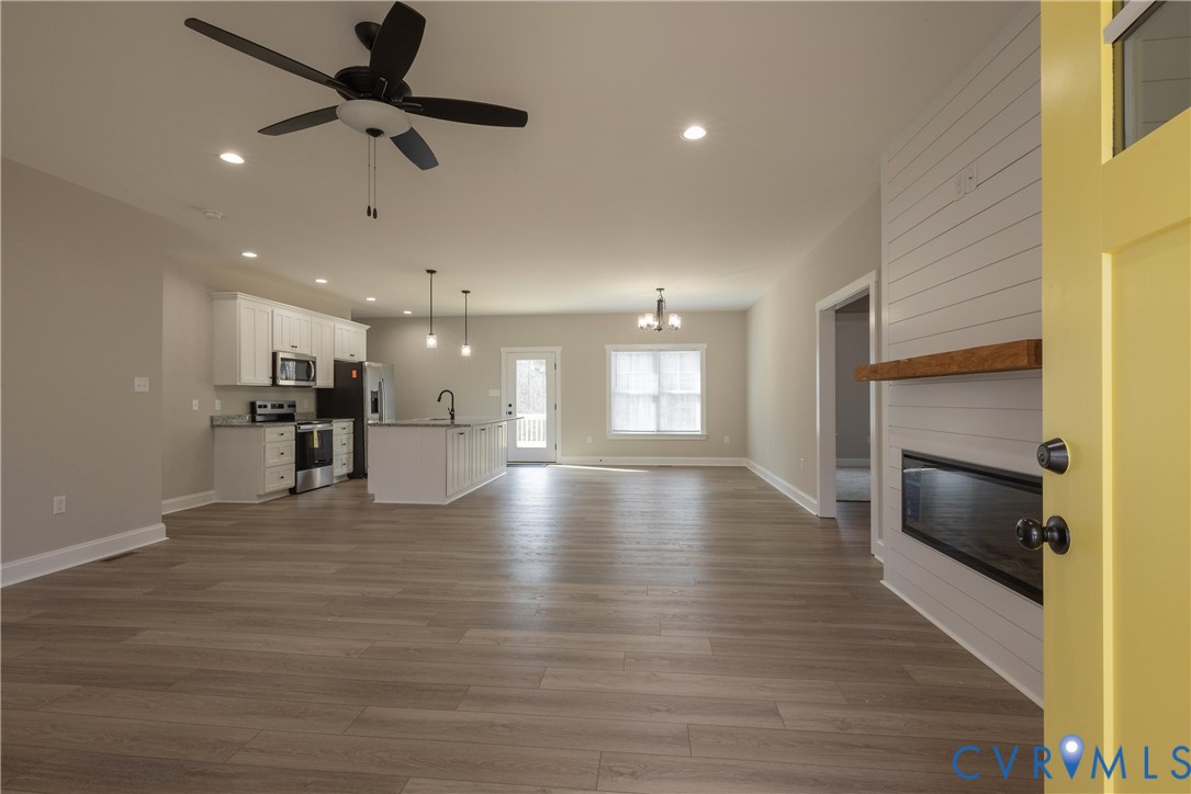 2223 Ridge Road Arvonia, VA 23004 - Photo 9 of 45 a view of a kitchen and an empty room with wooden floor and a kitchen