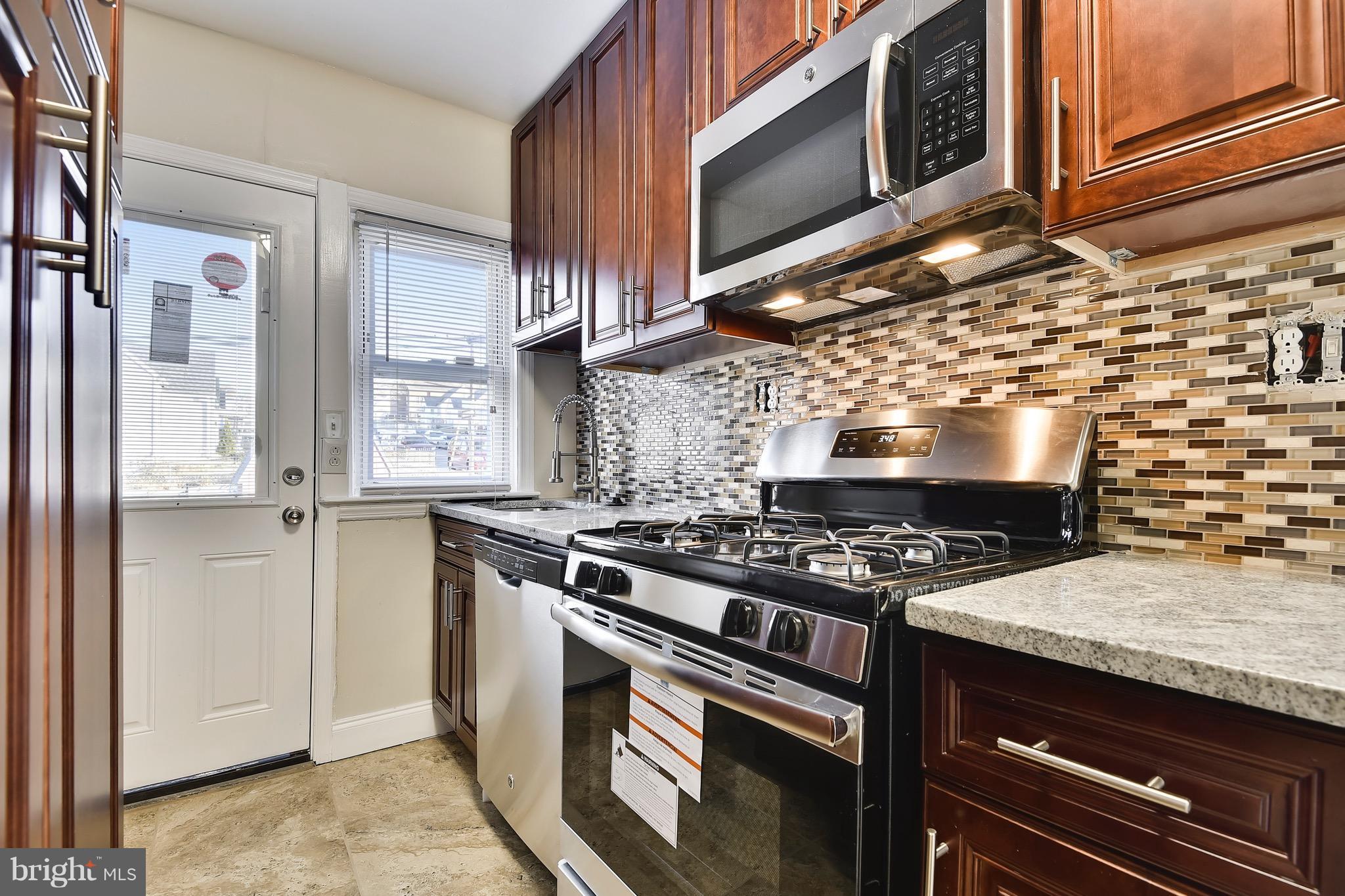 227 Old Riverside Road Baltimore, MD 21225 - Photo 8 of 20 a kitchen with stainless steel appliances granite countertop wooden cabinets and a stove top oven