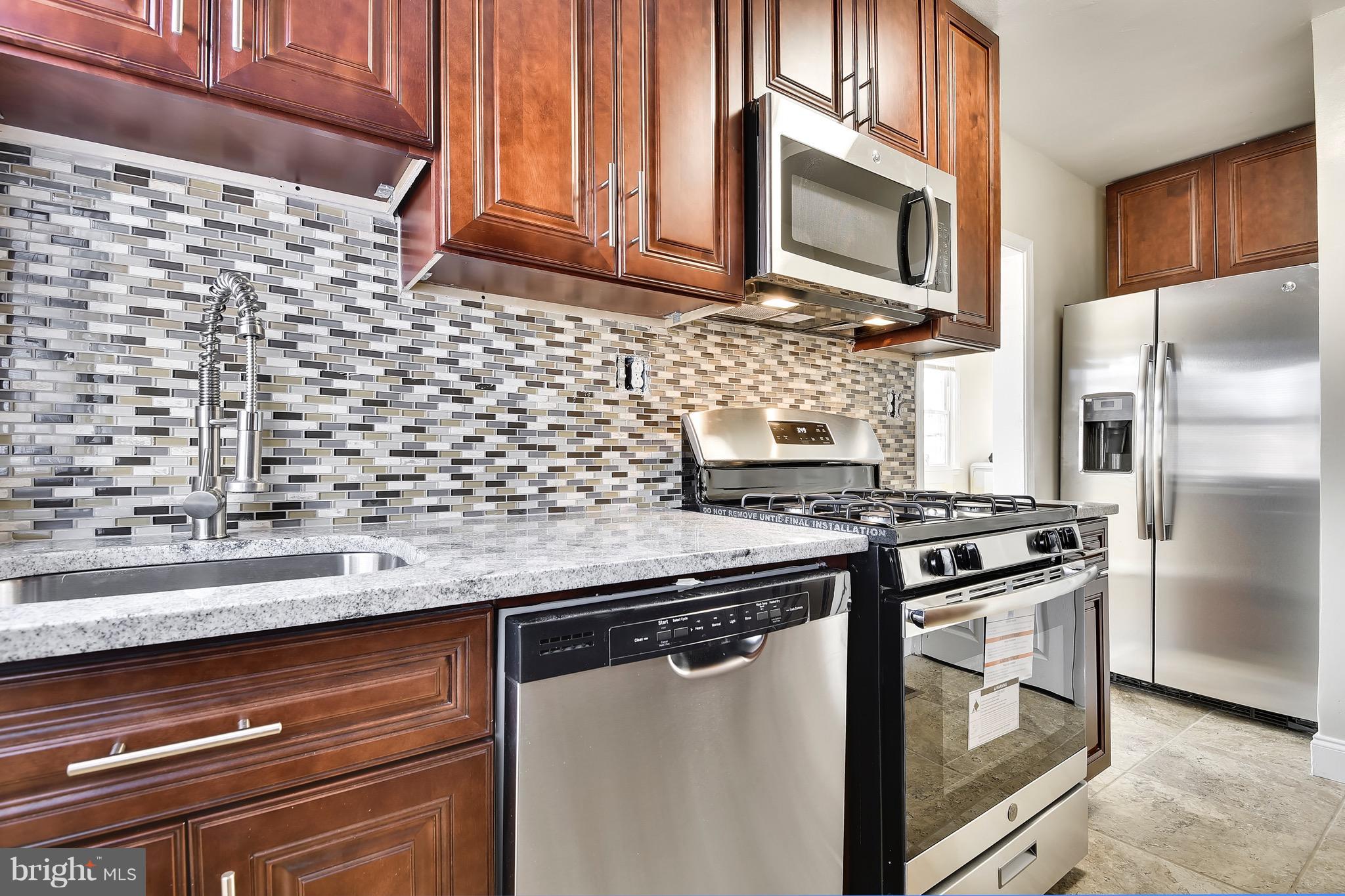 227 Old Riverside Road Baltimore, MD 21225 - Photo 9 of 20 a kitchen with stainless steel appliances granite countertop a sink stove and refrigerator