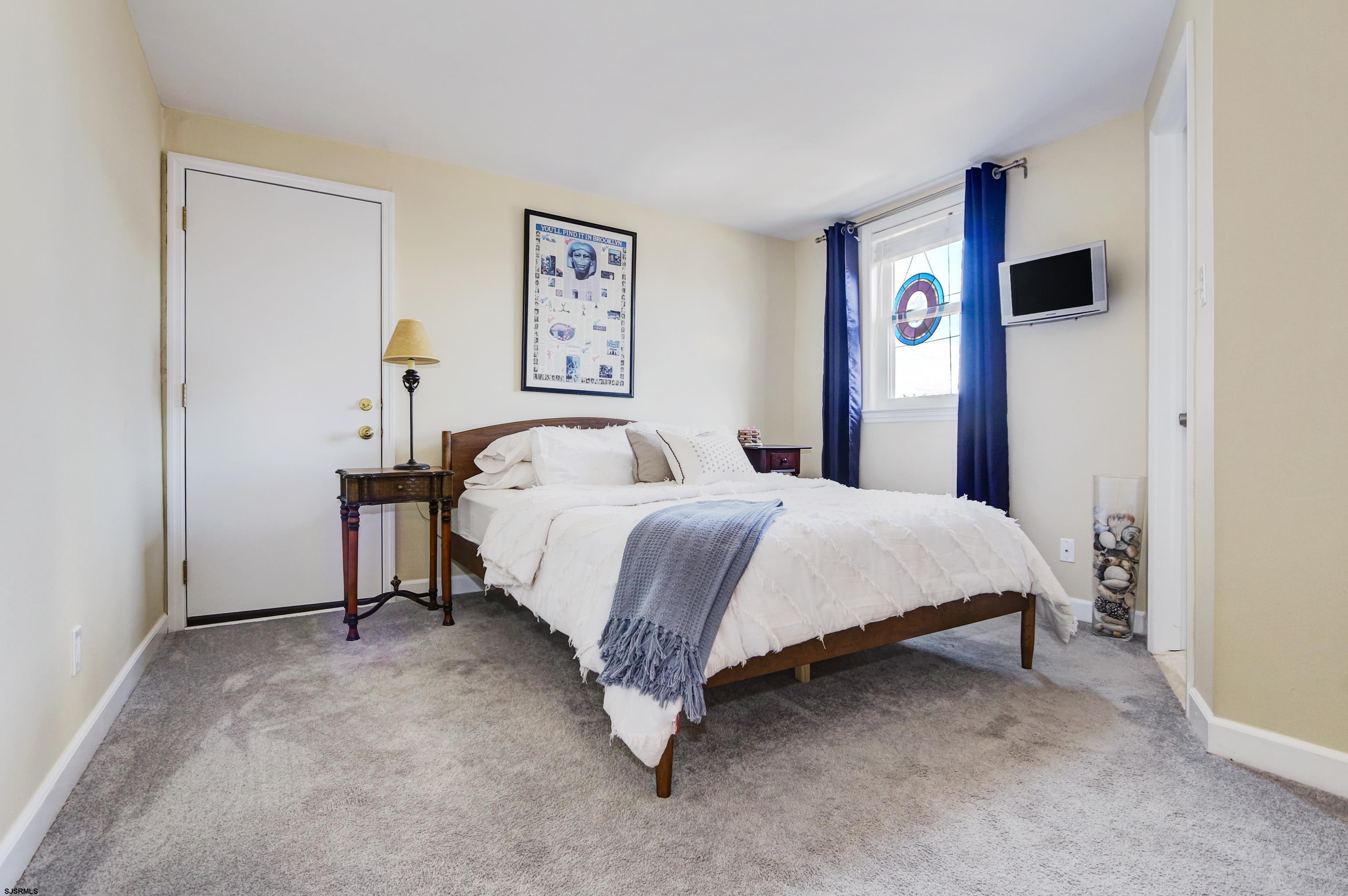 9801 Ventnor Avenue, Unit B1 Margate City, NJ 08402 - Photo 12 of 23 a bedroom with a bed and painting on the wall