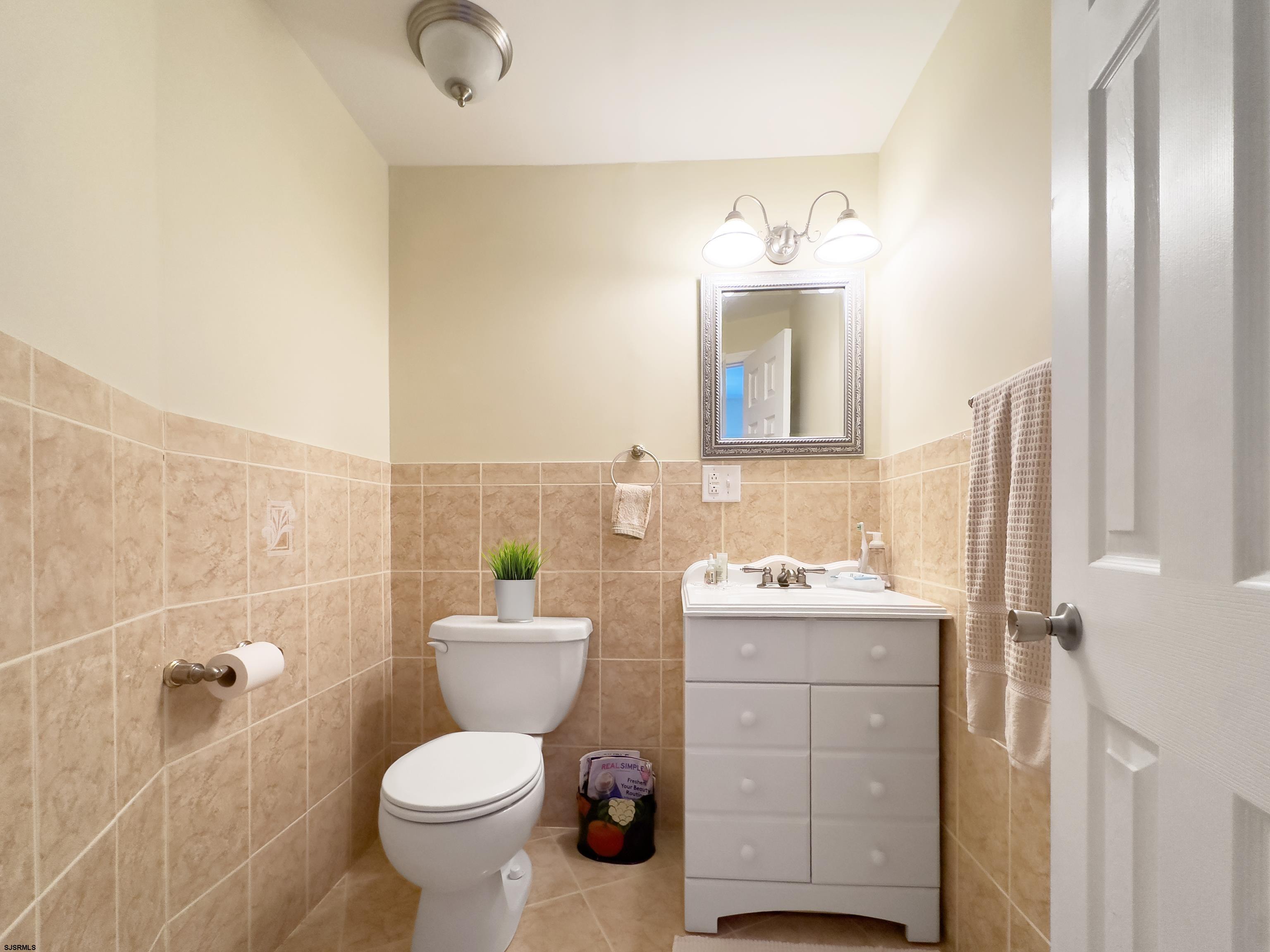 9801 Ventnor Avenue, Unit B1 Margate City, NJ 08402 - Photo 14 of 23 a bathroom with a toilet sink and mirror