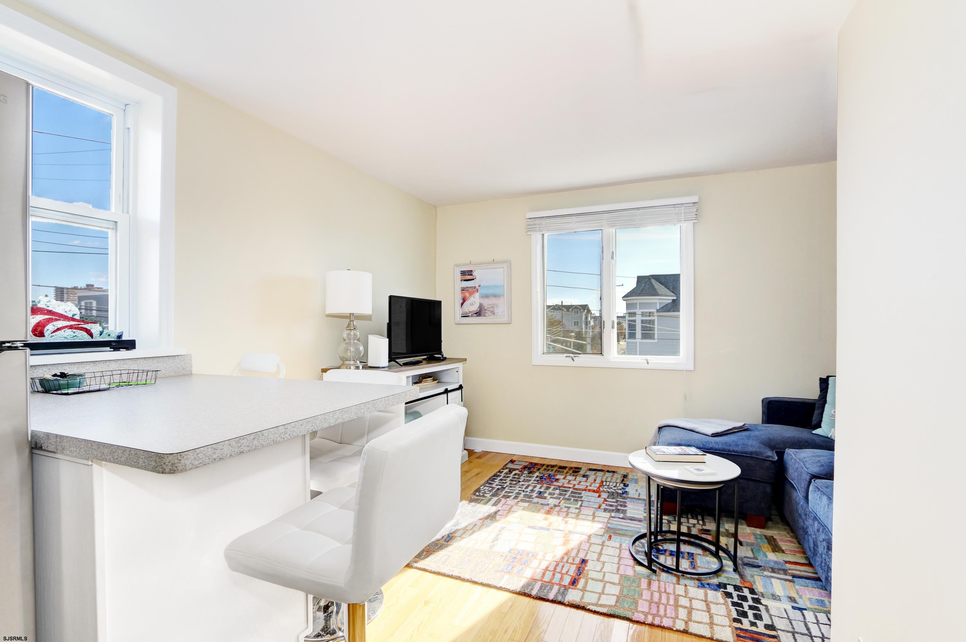 9801 Ventnor Avenue, Unit B1 Margate City, NJ 08402 - Photo 7 of 23 a living room with furniture a flat screen tv and a window