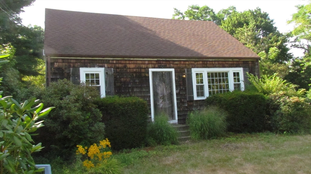 a front view of house with a garden