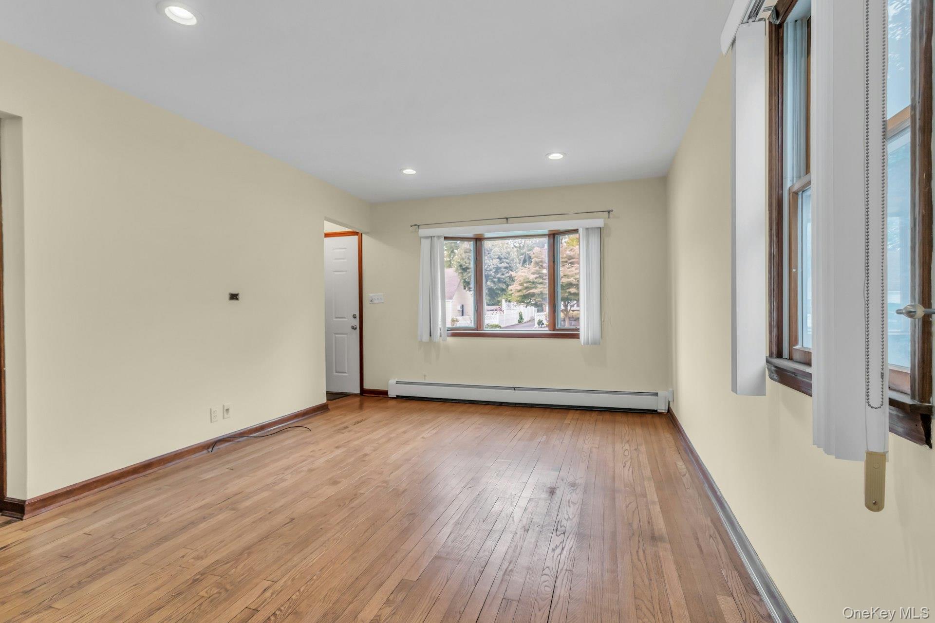 4 Timber Road Glen Cove, NY 11542 - Photo 5 of 30 an empty room with wooden floor and windows