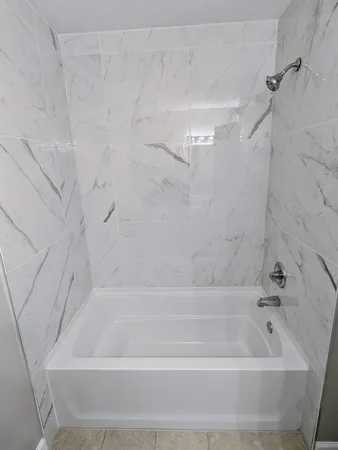 a bathroom with a shower and a bath tub