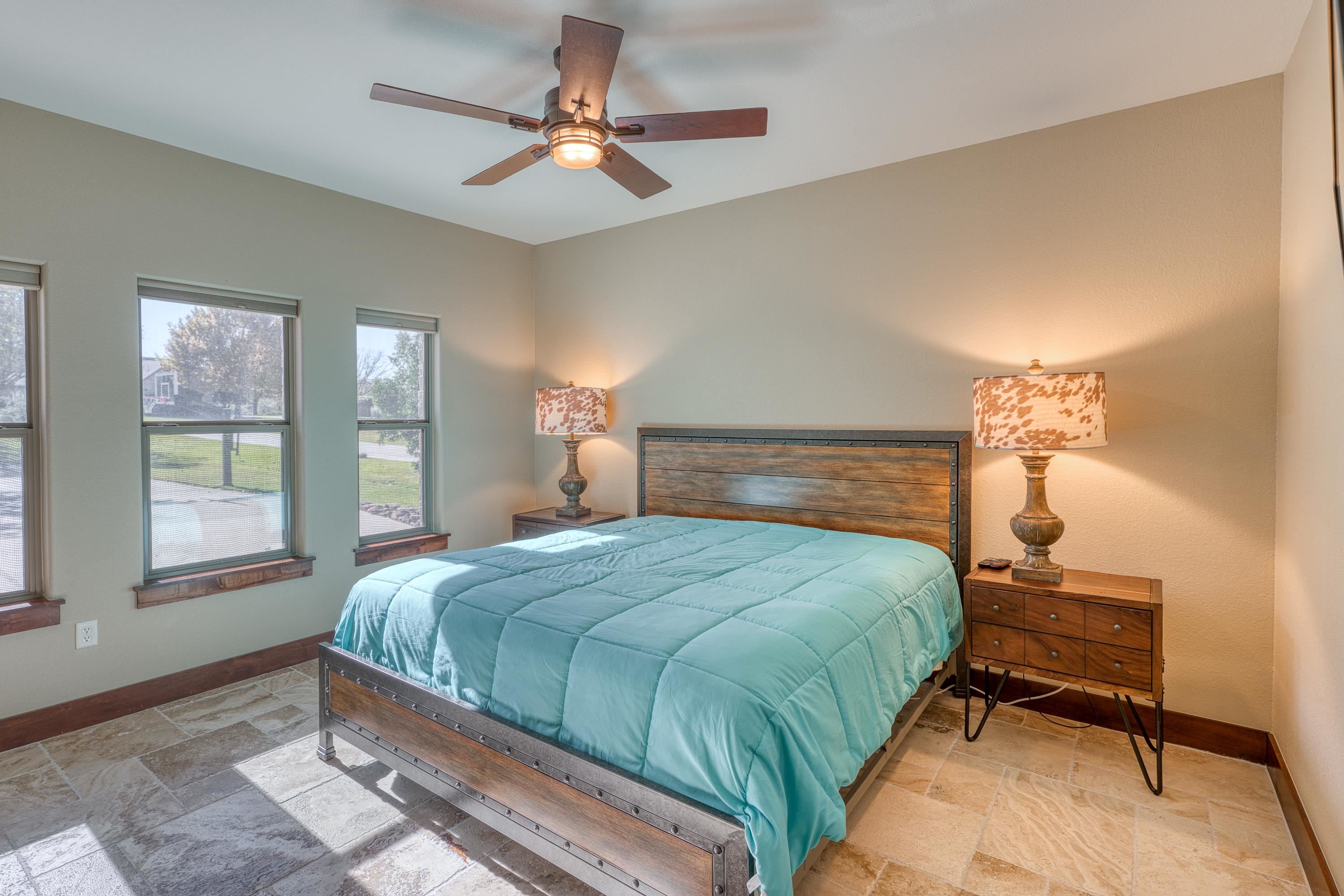 206 River Ranch Road Kingsland, TX 78639 - Photo 11 of 30 a bedroom with a bed and a chandelier