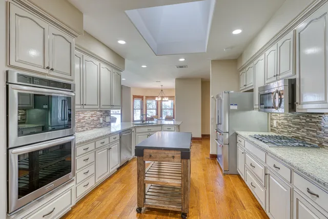 a dining room with furniture a chandelier and wooden floor