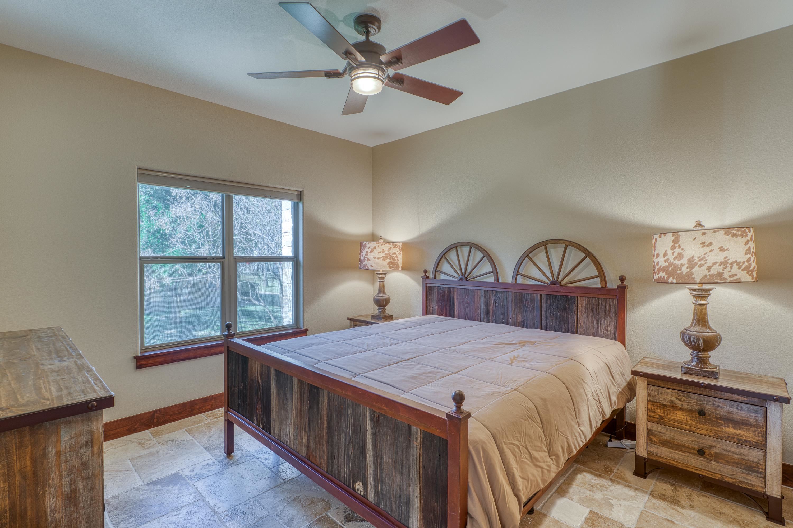 206 River Ranch Road Kingsland, TX 78639 - Photo 15 of 30 a bedroom with a bed a chandelier and a window
