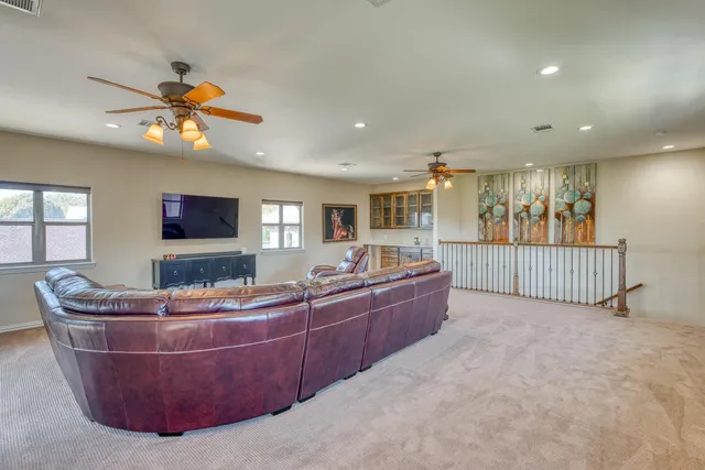 a living room with furniture a ceiling fan and a window