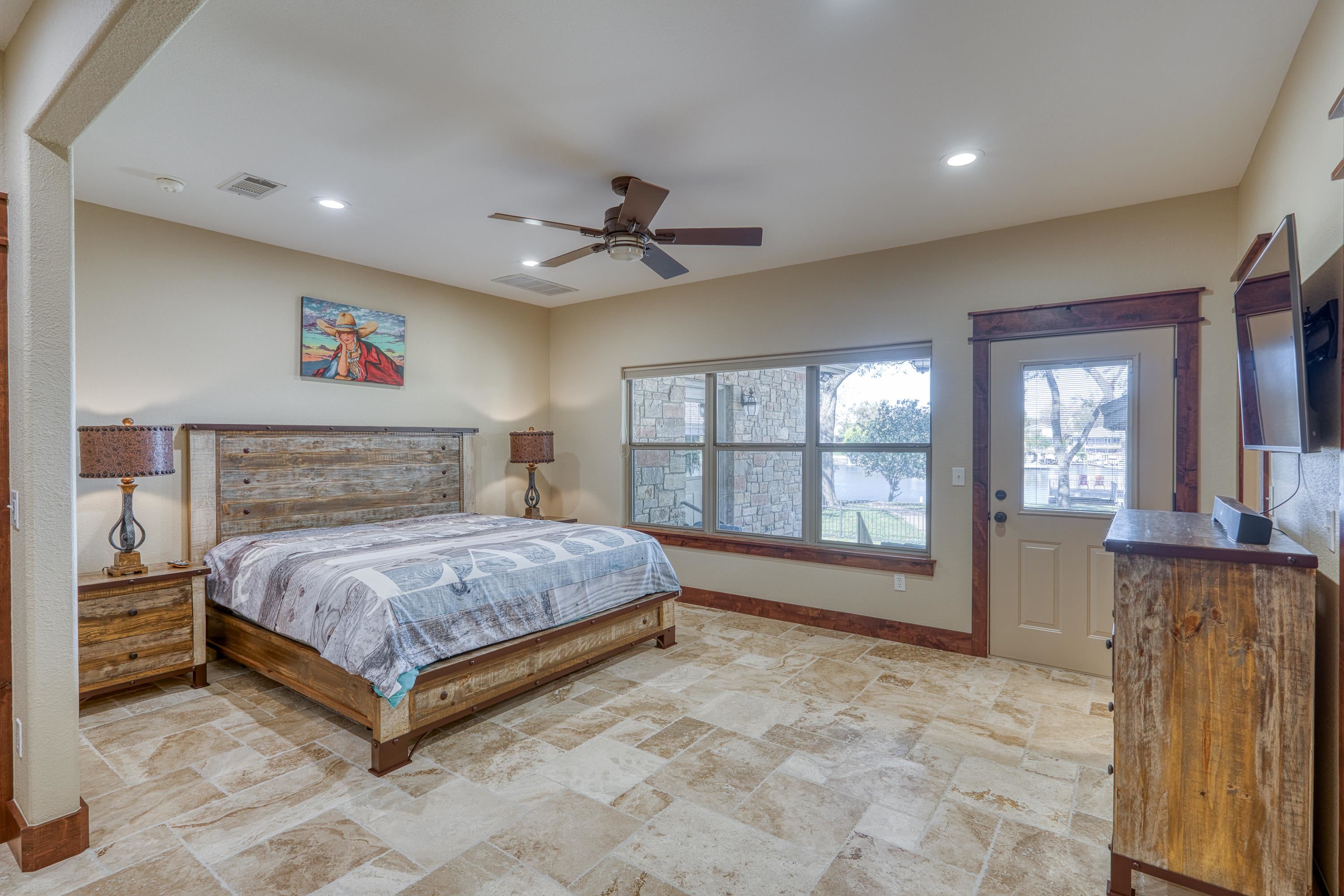206 River Ranch Road Kingsland, TX 78639 - Photo 21 of 30 a spacious bedroom with a bed and a large window