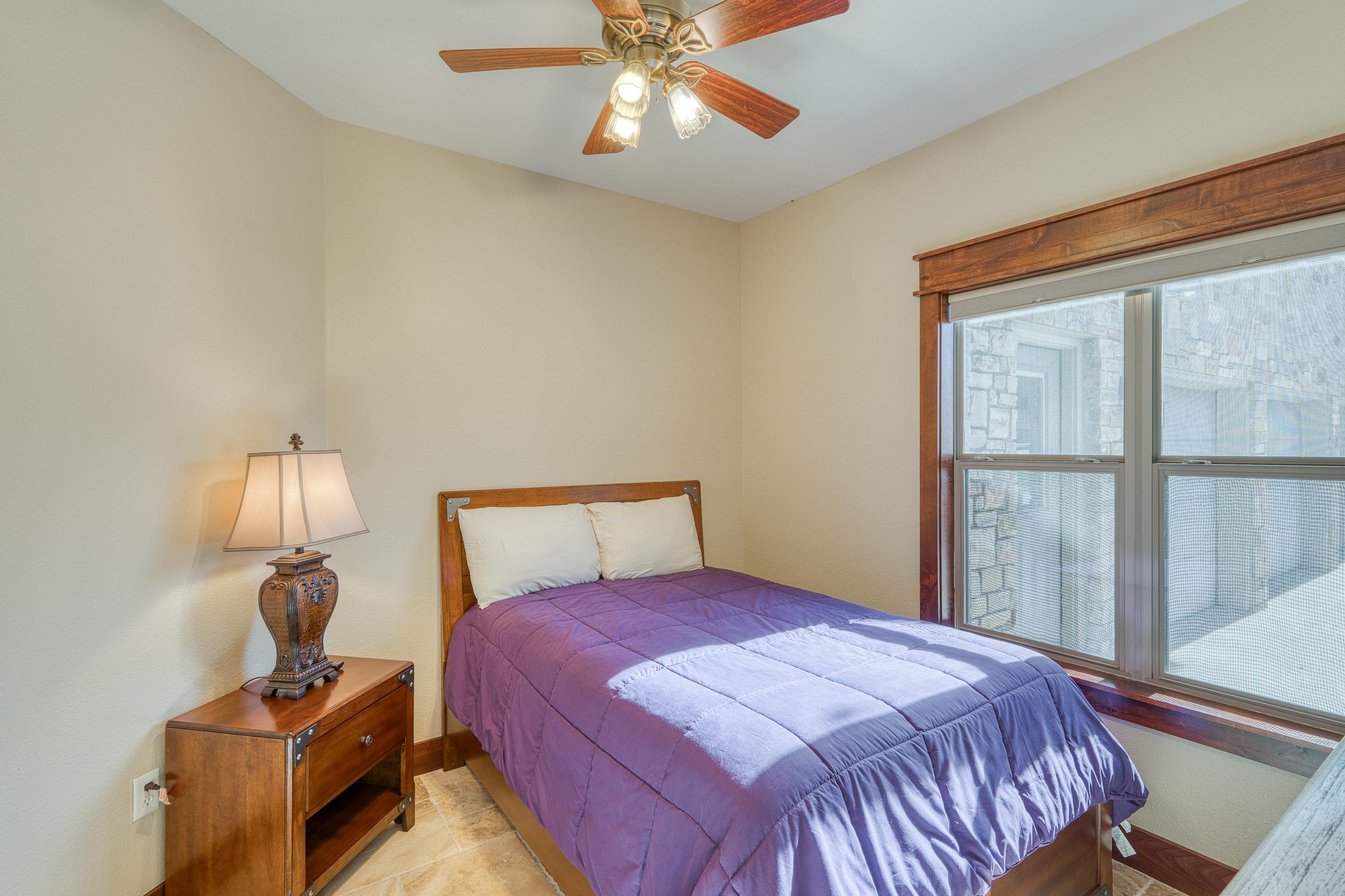 206 River Ranch Road Kingsland, TX 78639 - Photo 10 of 30 a bedroom with a bed and a lamp on table